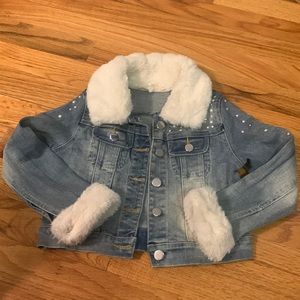 light denim jean jacket with pearls and rhinestone around the shoulder and arms.